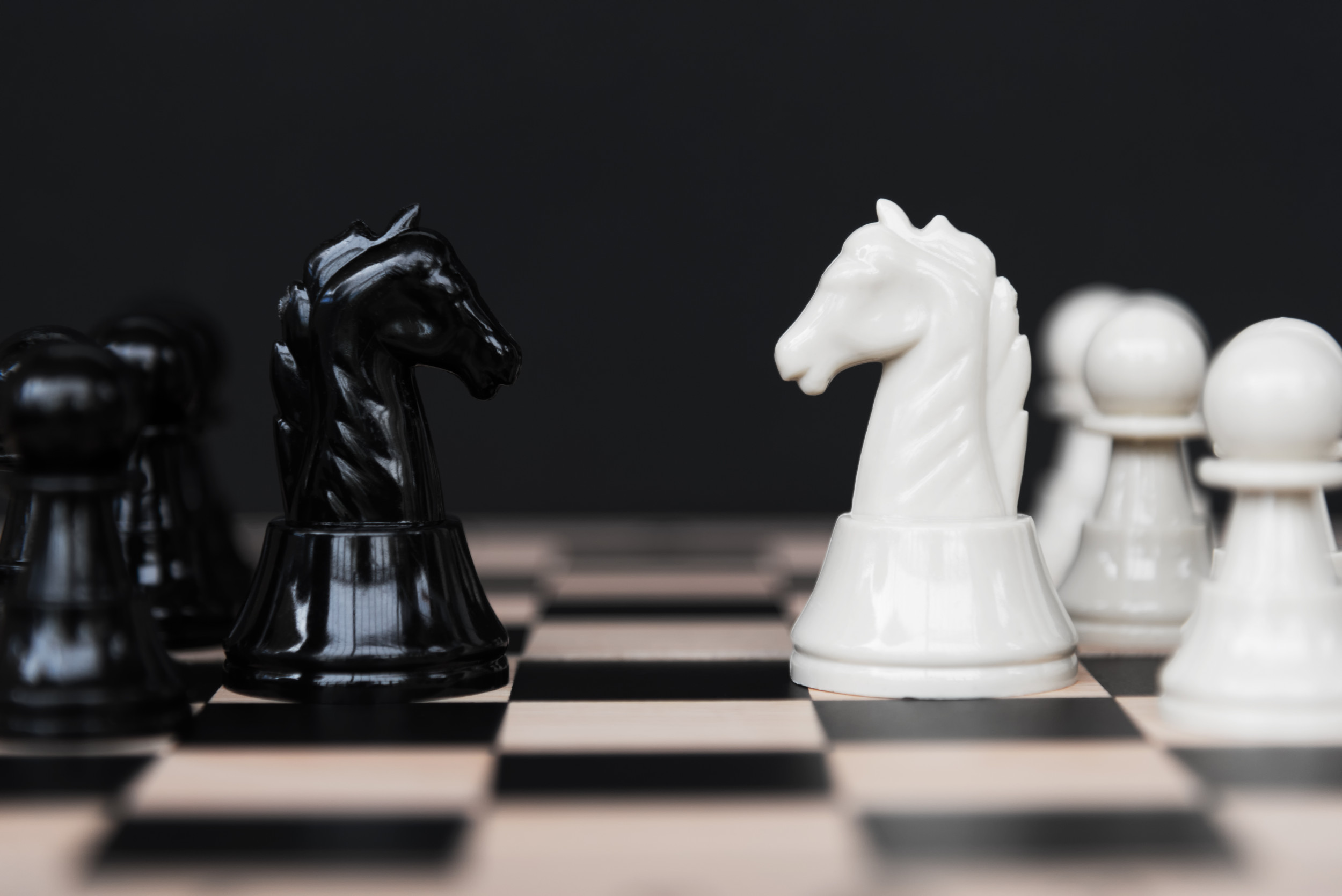 Premium Photo Three pieces on a dark chessboard