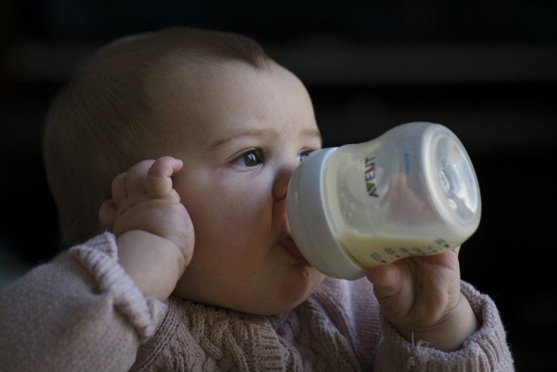 Baby feeds herself bottle of milk