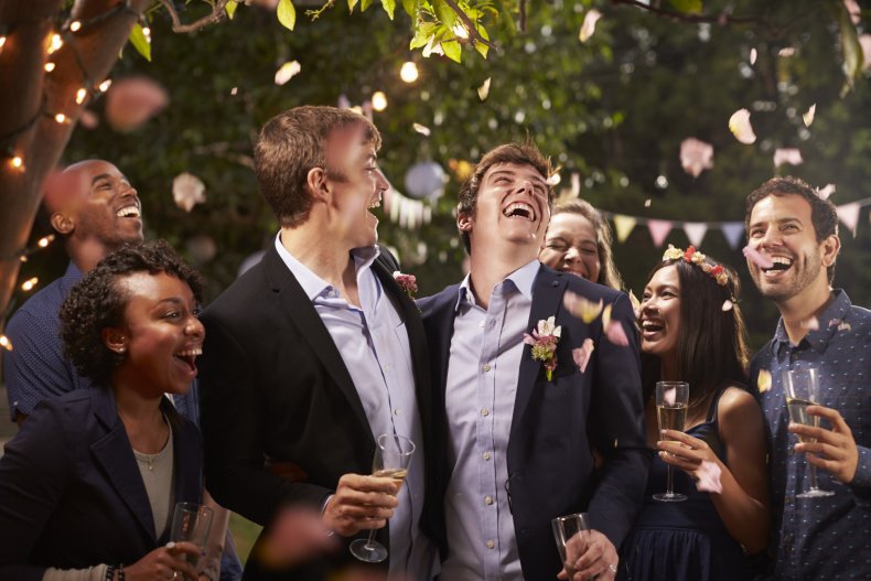 Grooms surrounded by wedding guests