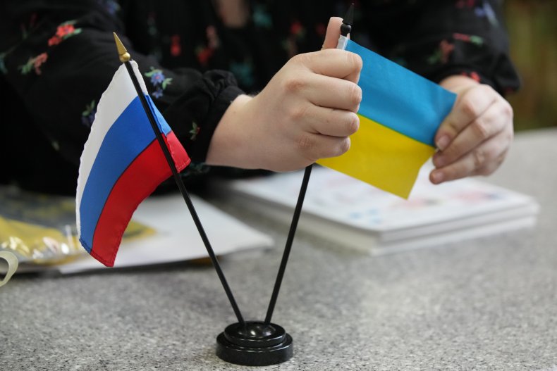A worker displays Russian and Ukrainian flag