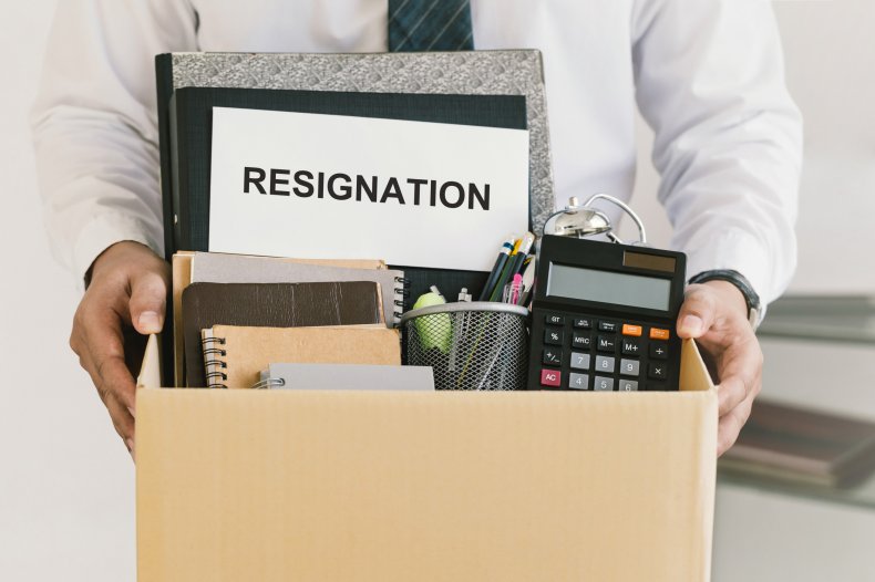 A person holding box with office supplies.