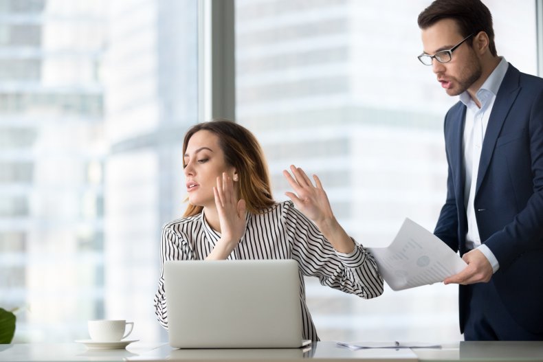 Woman in office with hands up.