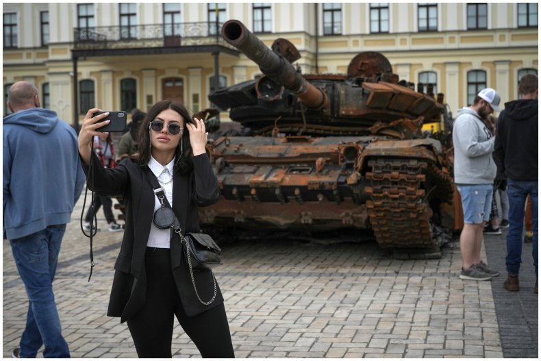 Woman taking selfie in front of tank