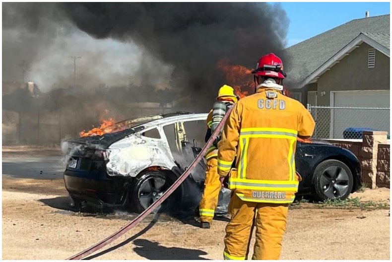 Firefighters putting out Tesla fire
