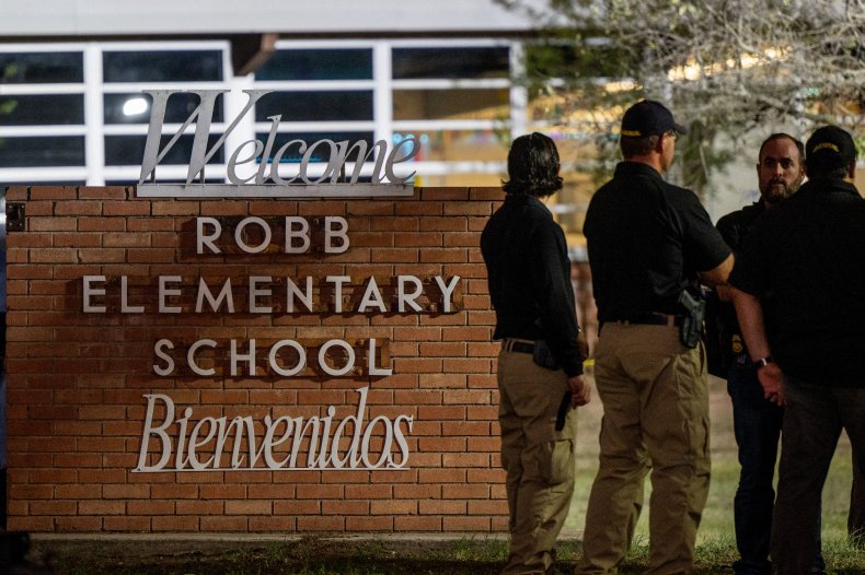 Officers speak together outside of Robb Elementary