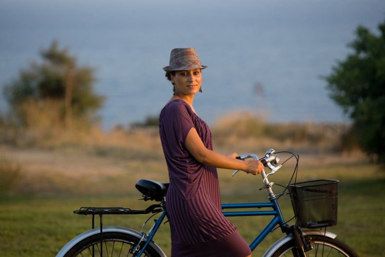Woman holding a bicycle in a field