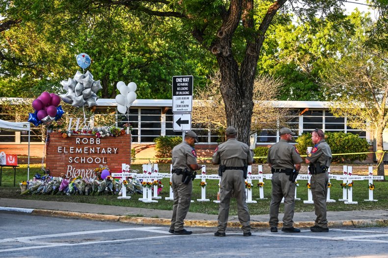 Police officers stand near a makeshift memorial 