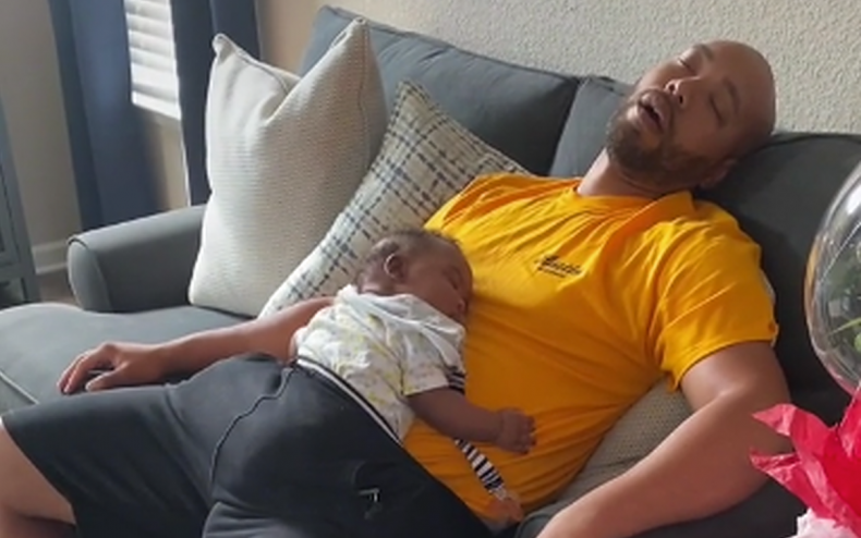 A dad and his sleeping baby.