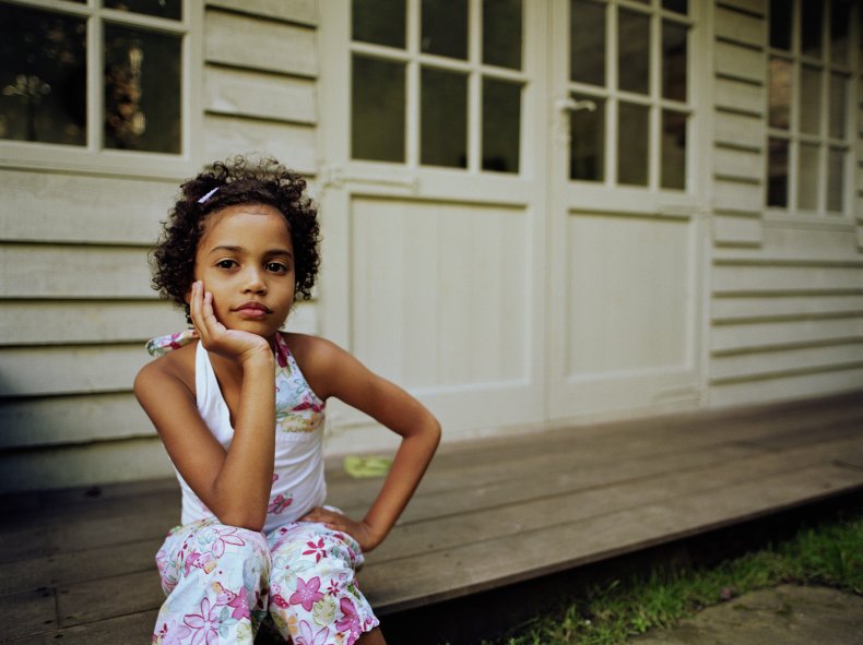 Girl sitting on porch looking at camera