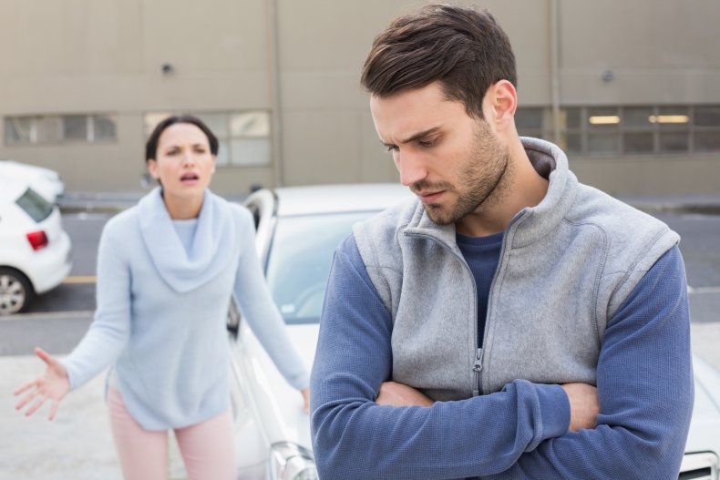 A couple arguing near a car.