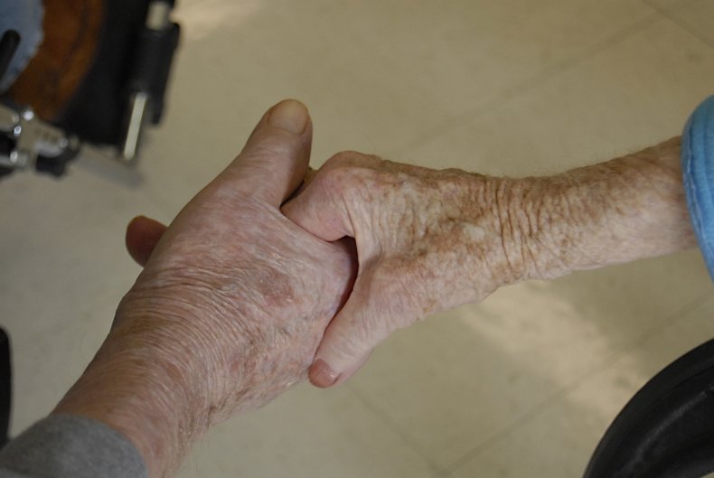 Old couple holds hands