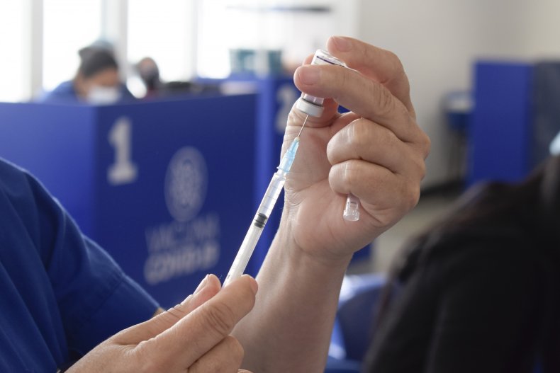 Un trabajador de la salud prepara una vacuna.