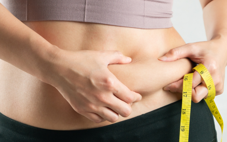 A woman preparing to weigh herself.