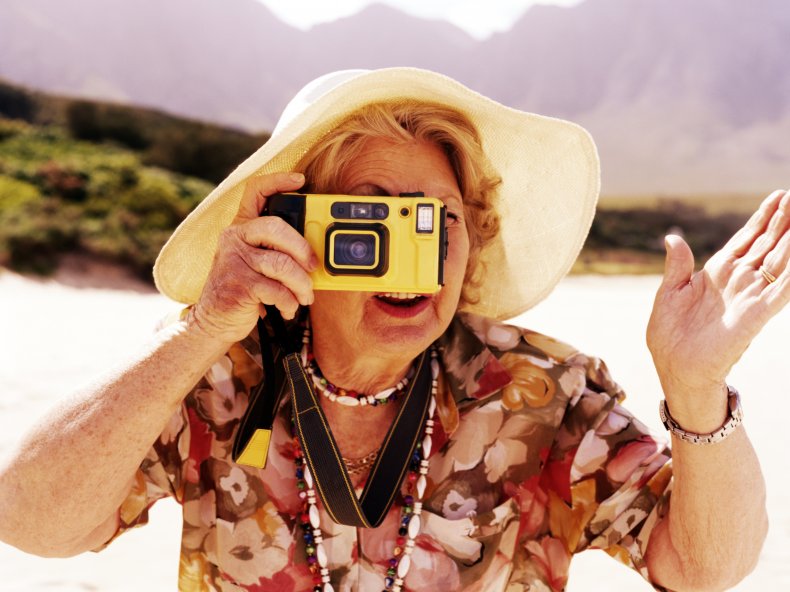 File photo of senior woman taking photograph.