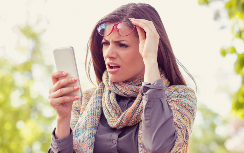 A woman reacting angrily to a text.