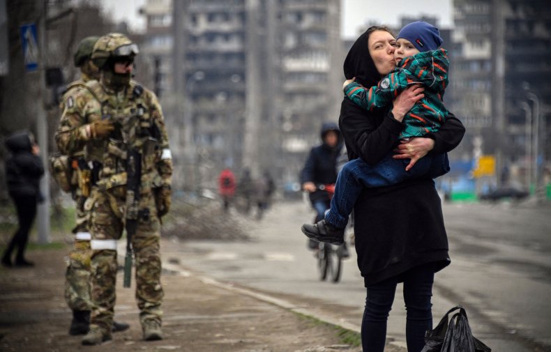A woman holds and kisses a child