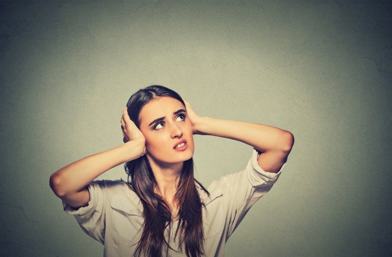 A woman covering ears.