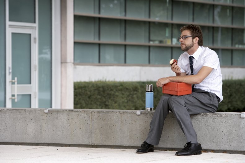 Man sits eating lunch on step