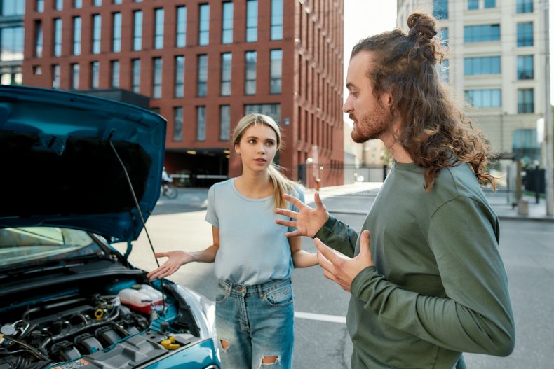 Couple arguing near broken down car.