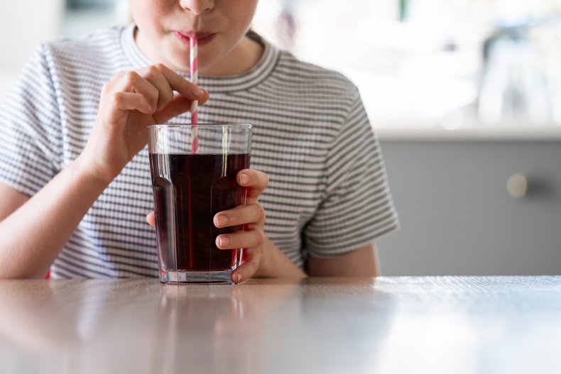 Child drinking soda with a straw