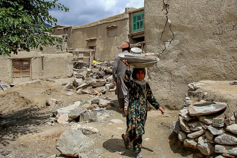 A child carrying utensils on her heads