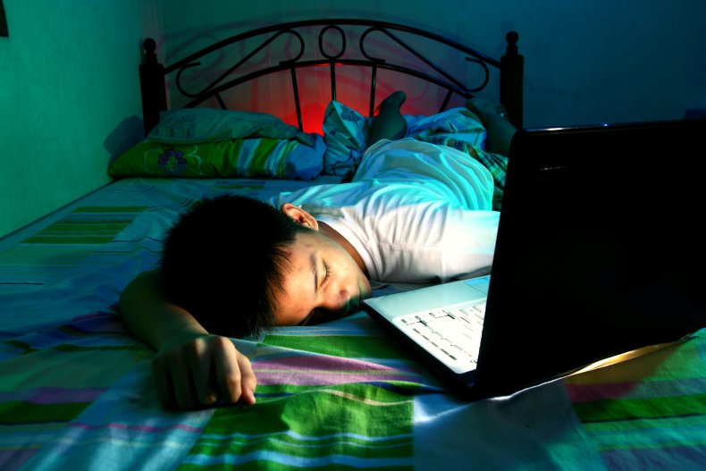 Boy sleeping with open laptop