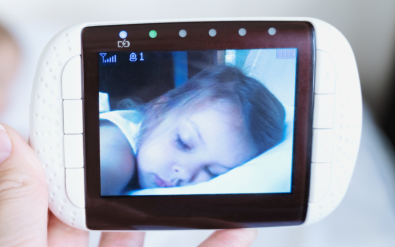 A toddler asleep on a baby camera.