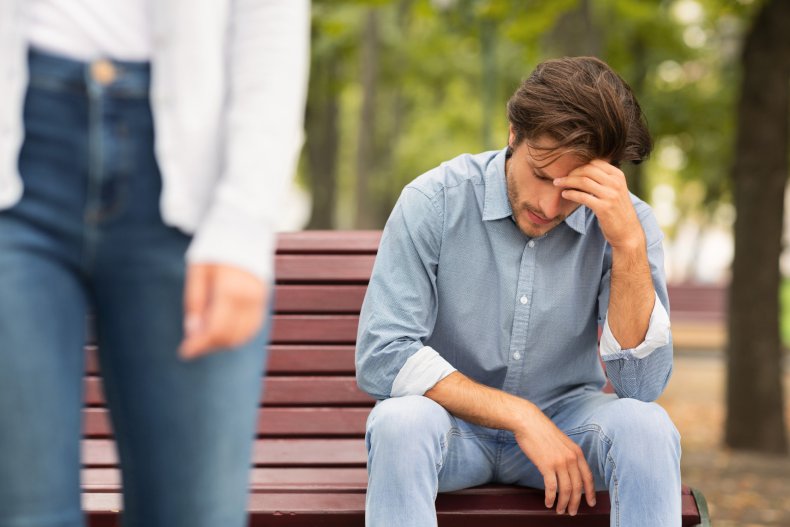 Woman leaves upset man sitting on bench