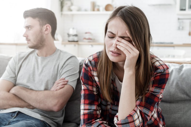 A couple arguming on a sofa.