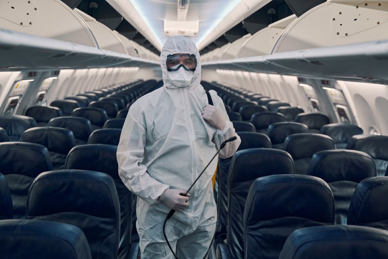 A person in hazmat suit on plane.