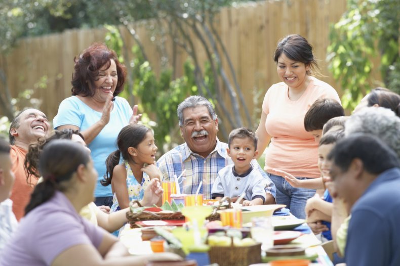 A family gathering over a meal outdoors.