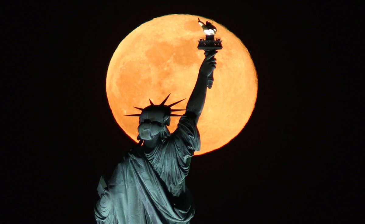 A supermoon above the Statue of Liberty