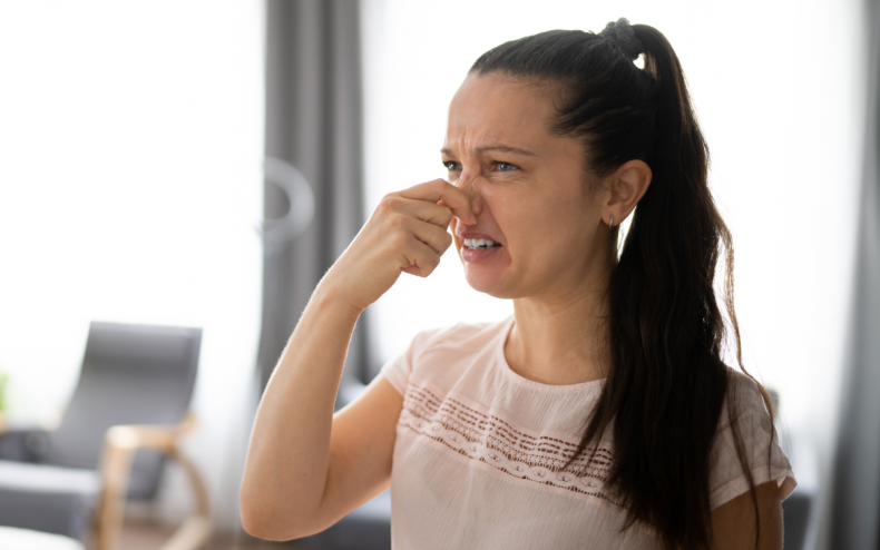 A woman reacting to a bad odor.