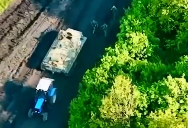 Ukraine troops use tractor to pull APC