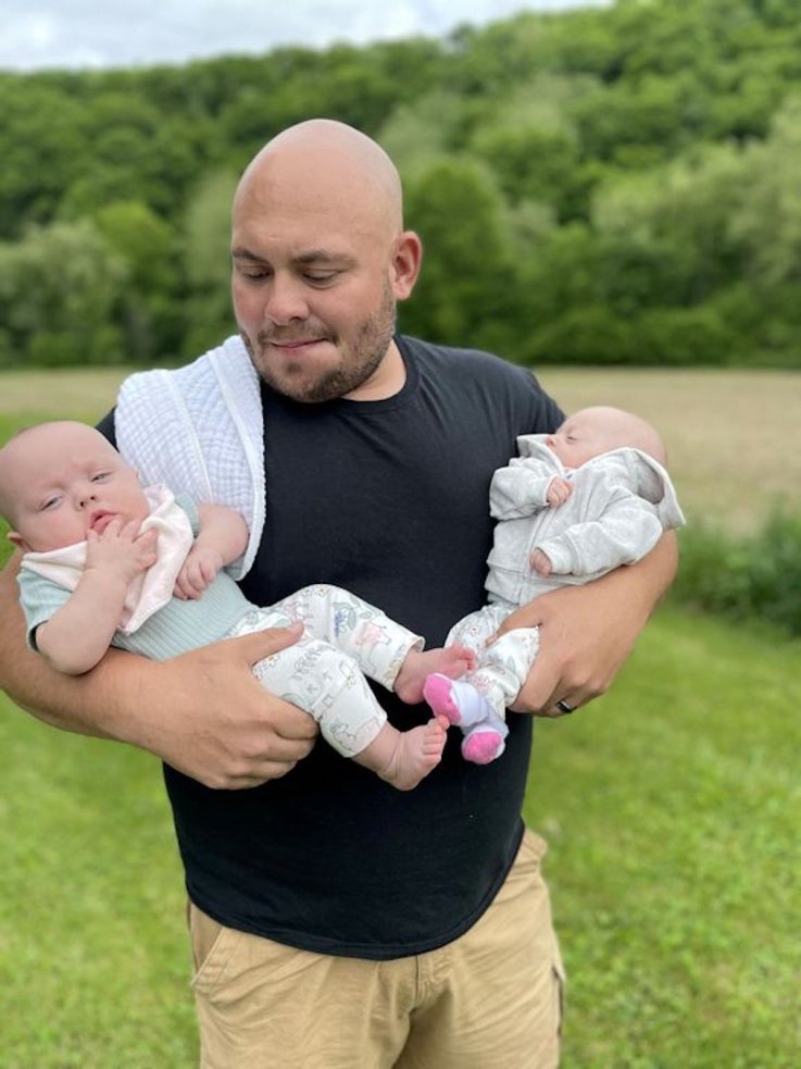 Chase Lamberts holds his twin daughters