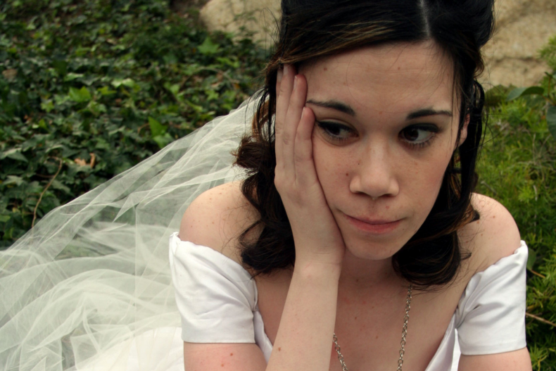 Upset bride sits on floor