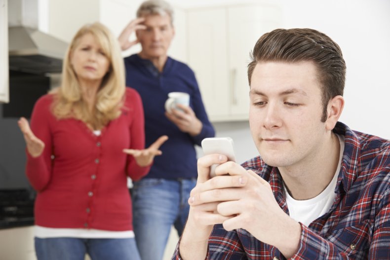 Frustrated parents watching man looking at phone.