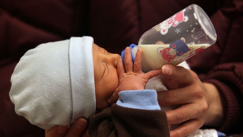 Baby drinks breast milk from a bottle
