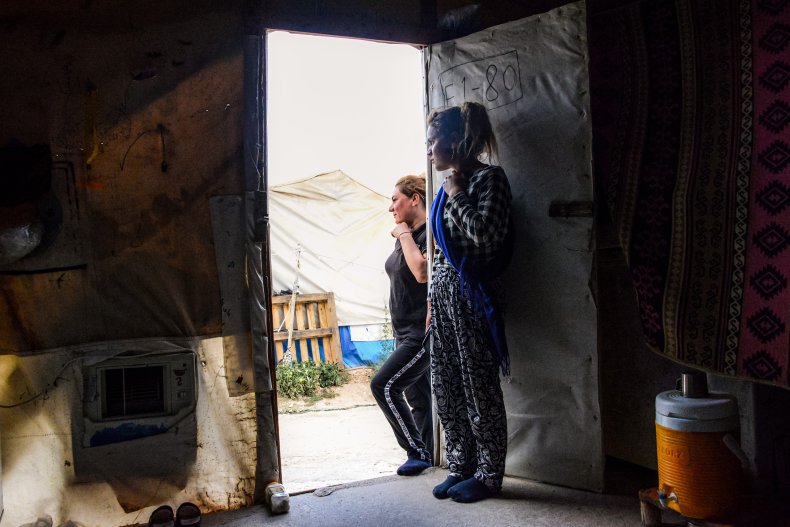Women stand through the doorway of shelter