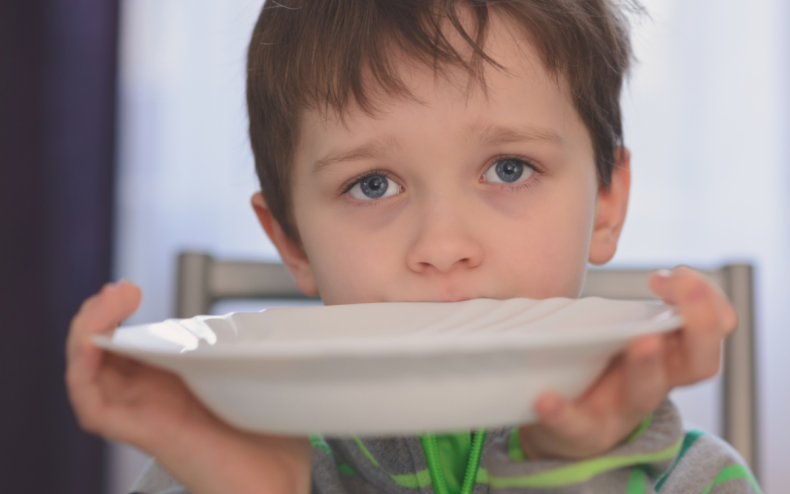 A boy with an empty bowl.