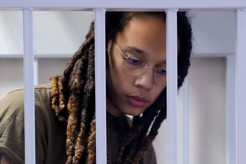 Brittney Griner sits in a defendants' cage