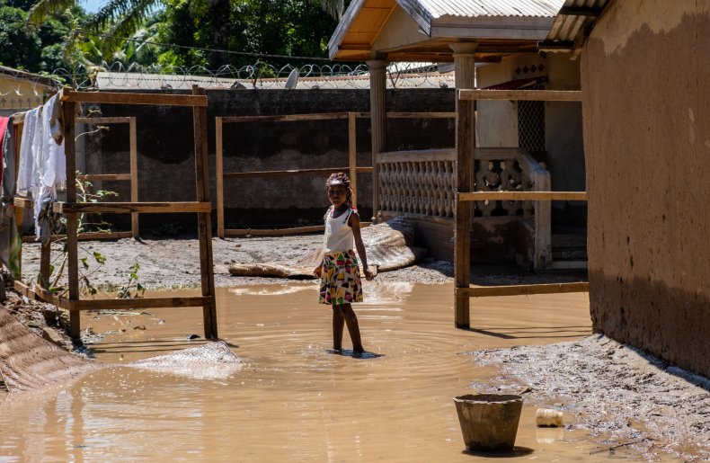 A young girl wades through flooded courtyard