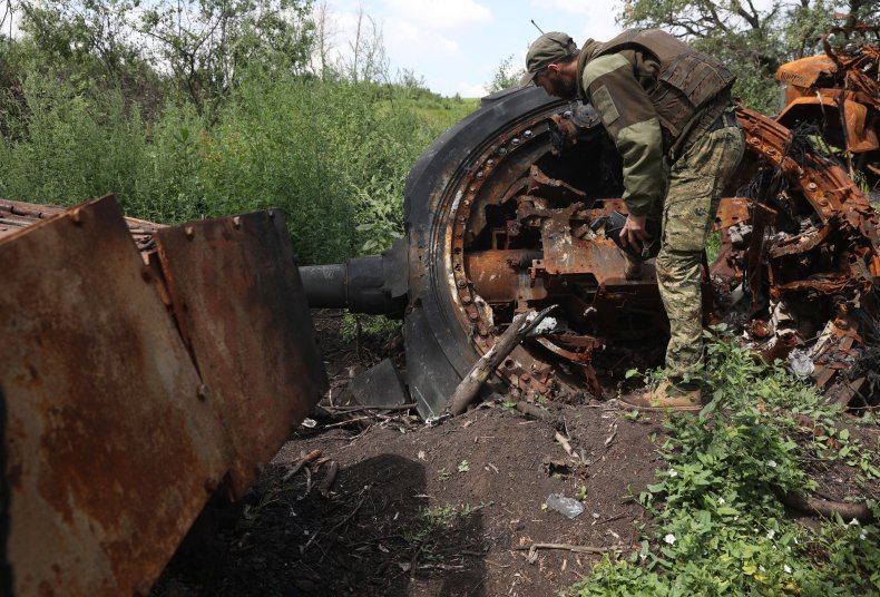 Ukrainian soldier inspects a destroyed Russian tank