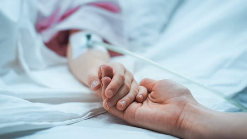 holding ill child's hands