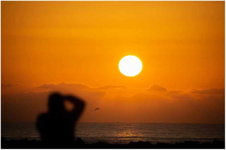 Man taking photo of a sunrise