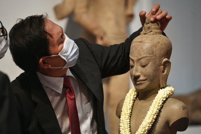 A statue is examined at a ceremony