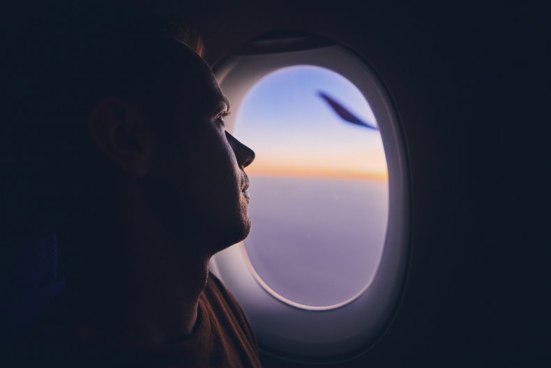 Man looks out airplane window