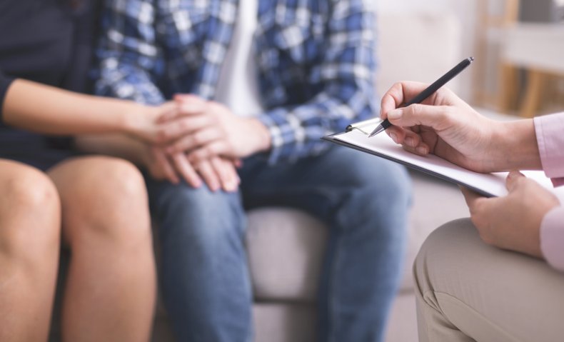 A couple holding hands during therapy session.