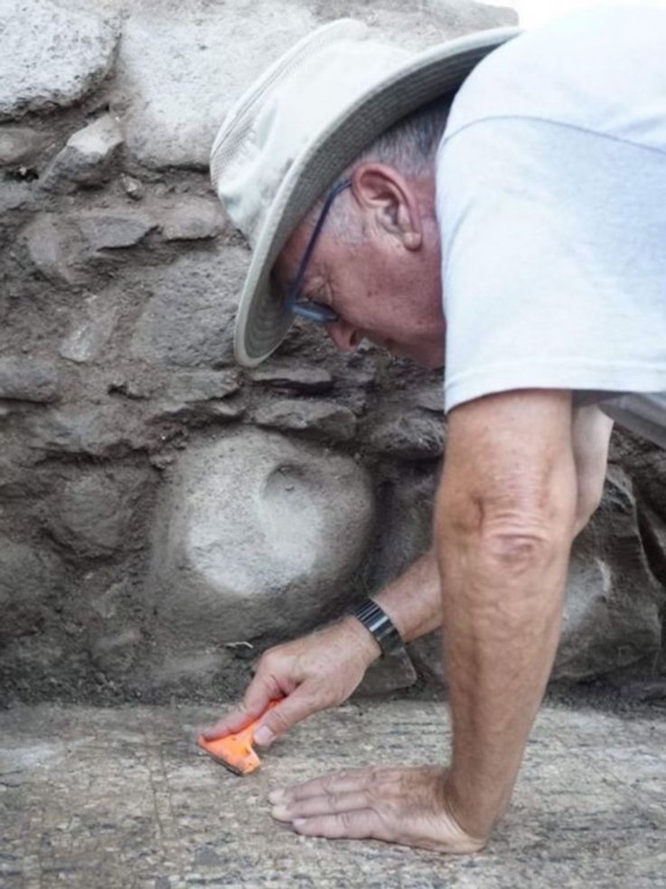 Mordechai Aviam cleans the inscription in Galilee
