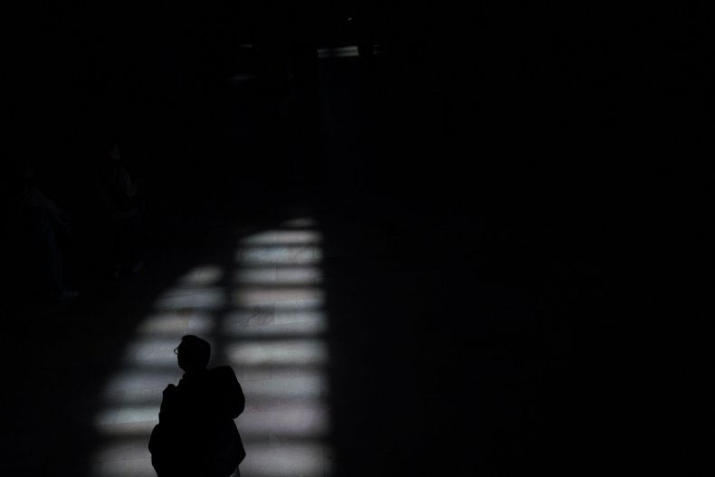 A person walks through afternoon shadows